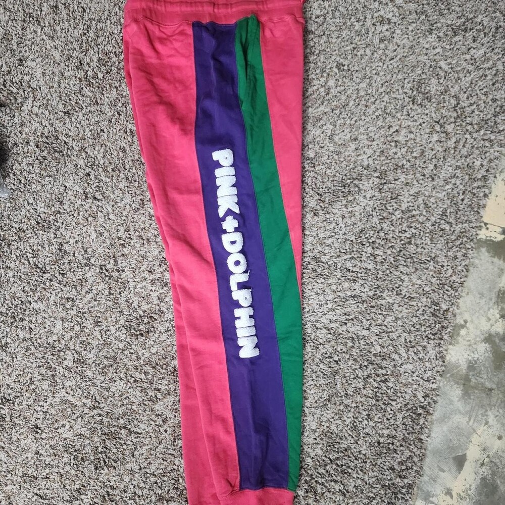 Pink Dolphin pink sweatpants with purple and green vertical stripes and white 'P